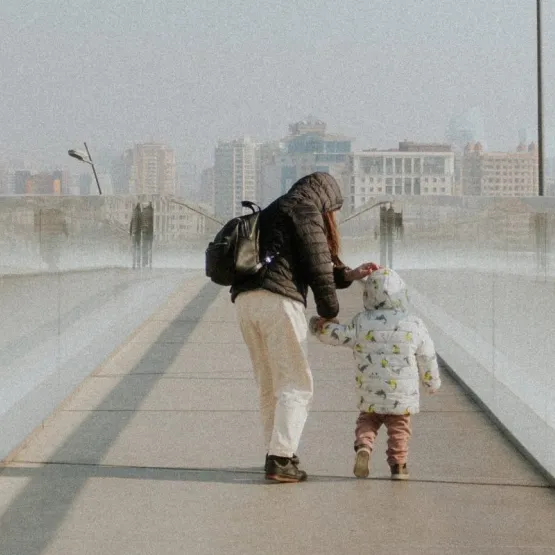 A woman and a todler walking over a bridge