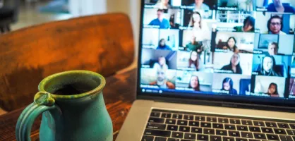 A laptop screen showing participants in a meeting