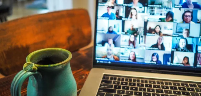 A laptop screen showing participants in a meeting