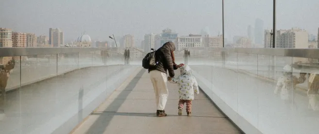 A woman and a todler walking over a bridge