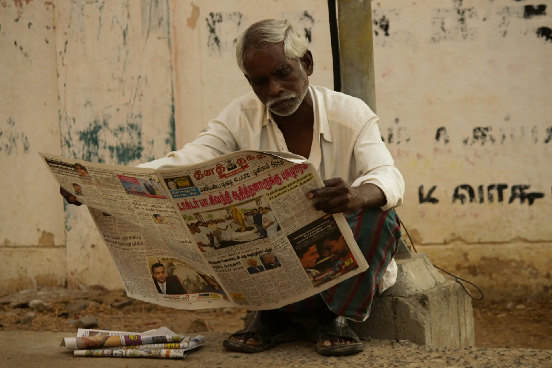 man reading newspaper south asia